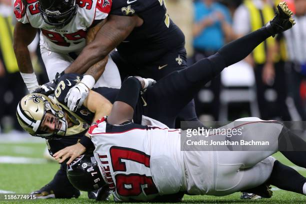 Drew Brees of the New Orleans Saints is sacked by Grady Jarrett of the Atlanta Falcons and Adrian Clayborn during the second half of a game at the...