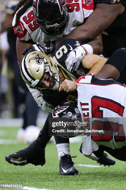 Drew Brees of the New Orleans Saints is sacked by Grady Jarrett of the Atlanta Falcons and Adrian Clayborn during the second half of a game at the...