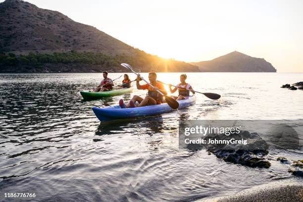 tandem kayakers paddling off the costa brava at dawn - using a paddle stock pictures, royalty-free photos & images