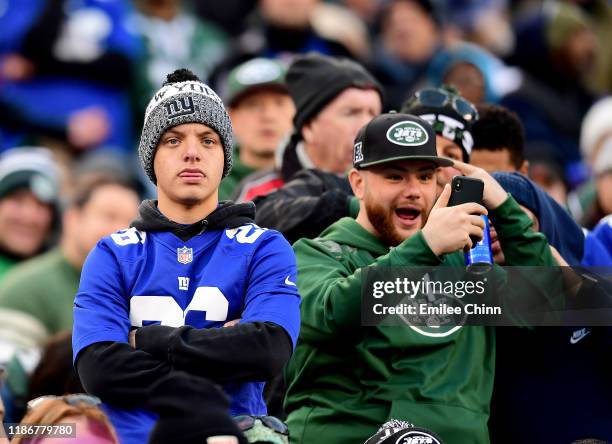 New York Jets fan celebrates as a New York Giants looks on during their game at MetLife Stadium on November 10, 2019 in East Rutherford, New Jersey....
