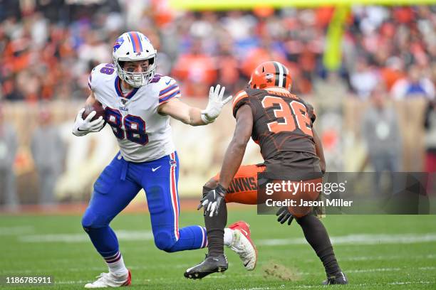 Tight end Dawson Knox of the Buffalo Bills tries to stiff-arm defensive back T.J. Carrie of the Cleveland Browns during the second half at...