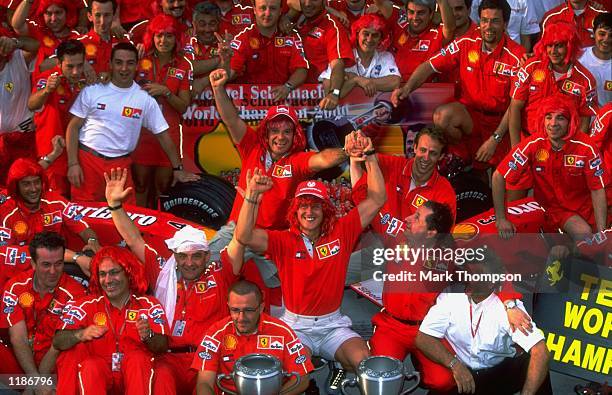 Michael Schumacher of Germany and Ferrari celebrates winning with the Ferrari team their two titles after the Malaysian Formula One Grand Prix at the...