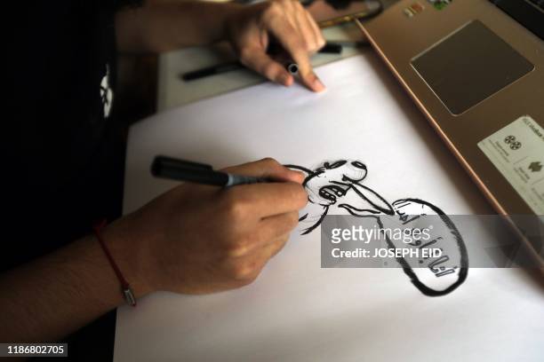 Lebanese cartoonist Mohamad Alameddine draws at his studio in the capital Beirut on December 6, 2019. - With anti-government protests sweeping across...
