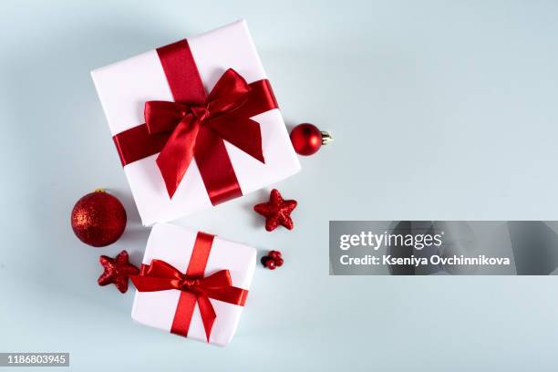 christmas background. red christmas present box, fir tree branch and decorations on blue. top view with copy space. - christmas background copy space stock pictures, royalty-free photos & images