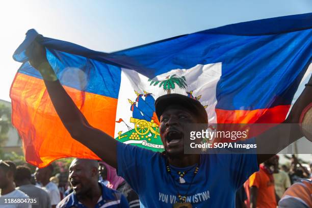 Demonstrator waves the Haitian flag while chanting anti-American slogans during the protest outside the US Embassy. For over a year tensions has been...
