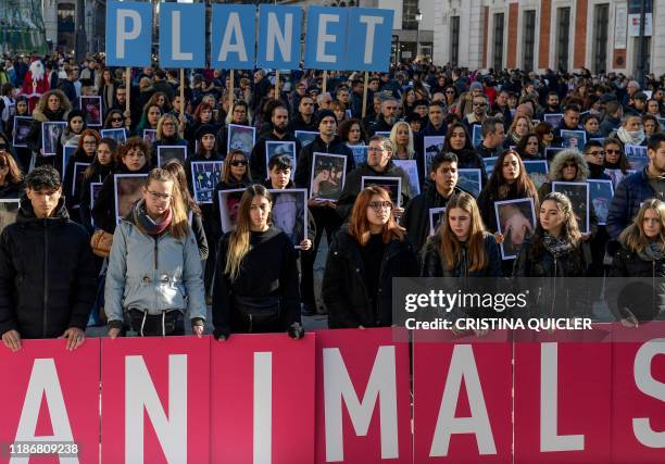 Demonstrators hold the slogan "Save the planet, save the animals" at La Puerta Del Sol in Madrid on December 7, 2019 during a protest called by...