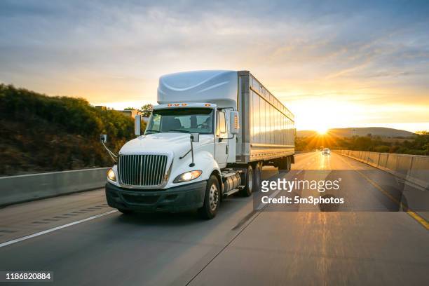 semi truck 18 wheeler on the highway at sunset - 2019 truck stock-fotos und bilder