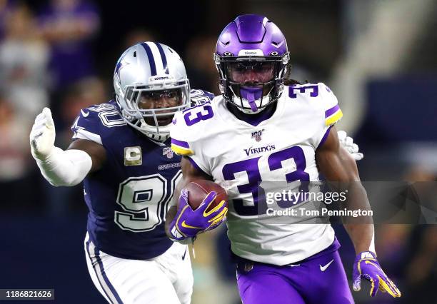 Dalvin Cook of the Minnesota Vikings runs with the ball as he is pursued by DeMarcus Lawrence of the Dallas Cowboys during the first half at AT&T...