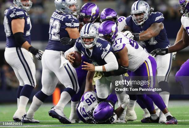 Dak Prescott of the Dallas Cowboys is sacked by Everson Griffen and Armon Watts of the Minnesota Vikings during the first half at AT&T Stadium on...