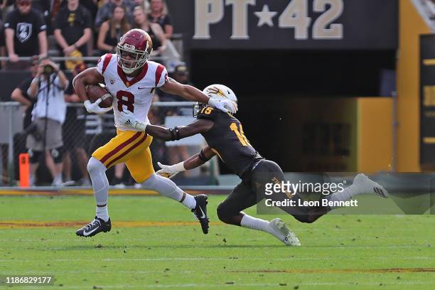 Wide receiver Amon-Ra St. Brown of the USC Trojans carries the ball against safety Cam Phillips of the Arizona State Sun Devils during a college...