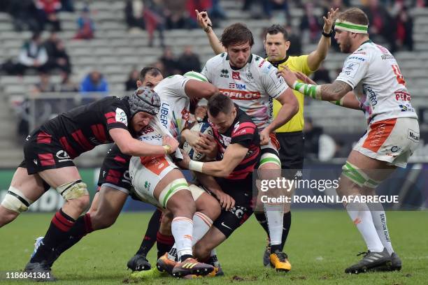 Lyon's New Zealand wing Toby Arnold fights for the ball as English referee Karl Dickson gestures during the European Rugby Champions Cup Pool 1 rugby...