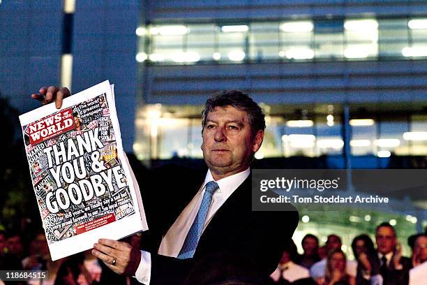 News of The World Editor Colin Myler holds the front page of the last edition of the paper as he leads staff and journalists out of the Thomas More...