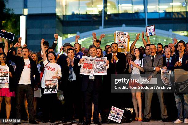 News of The World Editor Colin Myler holds the front page of the last edition of the paper as he leads staff and journalists out of the Thomas More...