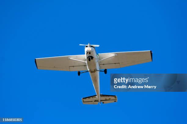 light aircraft flying overhead at takeoff with blue sky - propellermaschine stock-fotos und bilder