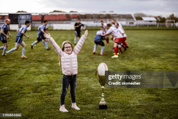 happy girl cheering during rugby match on playing field. - rugby union kids stock pictures, royalty-free photos & images
