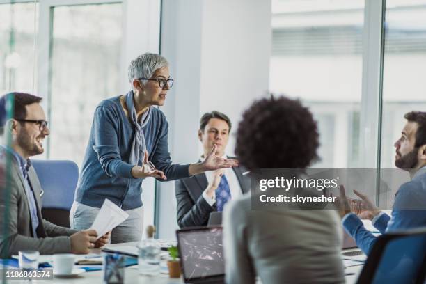 senior female leader arguing with her colleague on a meeting in the office. - communication problems stock pictures, royalty-free photos & images