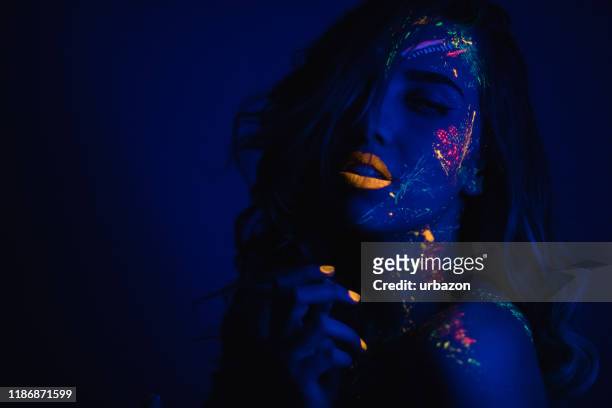 vrouw met fluorescerende make-up - body art stockfoto's en -beelden