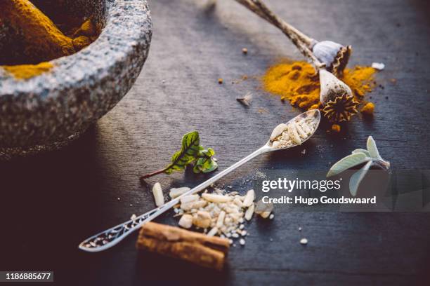 top-down view with organic herbs and cbd related natural medicine such as turmeric, ginger, cinnamon, aloe vera and poppy seeds. - ashwagandha stock-fotos und bilder