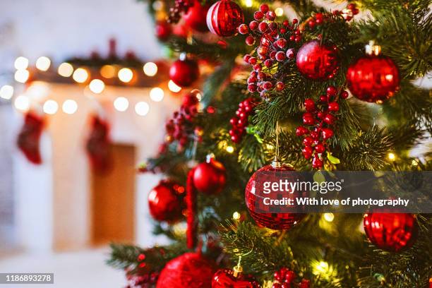 red christmas tree and fireplace decoration, merry christmas and happy new year, red and white christmas decor design, christmas background - christmas decorations - fotografias e filmes do acervo