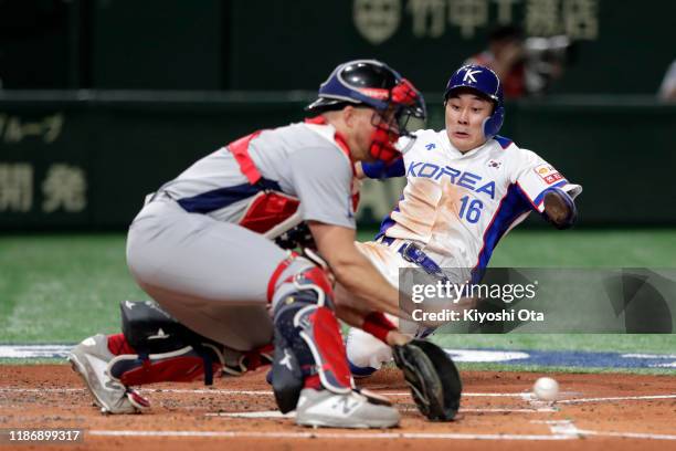 Infielder Kim Ha Seong of South Korea is tagged out by Catcher Erik Kratz of the United States on the home plate in the bottom of 3rd inning during...