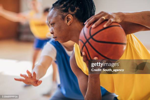 zwarte vrouw speelt basketbal binnenshuis - women's basketball stockfoto's en -beelden