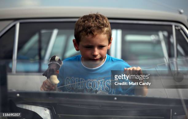 Boy stops to look in the interior of a classic car that is being displayed at the annual RNAS Yeovilton Air Day on July 9, 2011 in Yeovil, England....