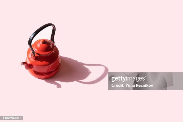 vintage red tea kettle on the pink background - theepot stockfoto's en -beelden