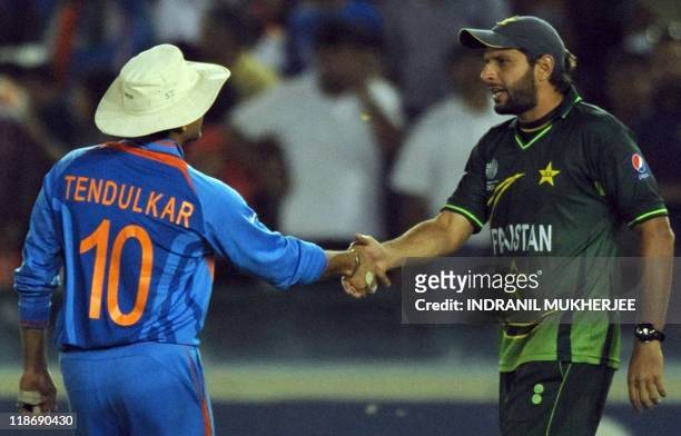 Pakistan captain Shahid Afridi greets Indian cricketer Sachin Tendulkar after the second semi-final match of The ICC Cricket World Cup 2011between...