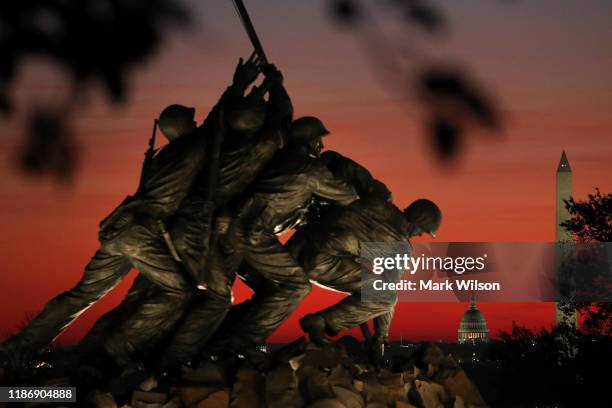The U.S. Marine Corp's Iwo Jima Memorial can be seen as the morning sun begins to rise behind the U.S. Capitol and Washington Monument on Veterans...