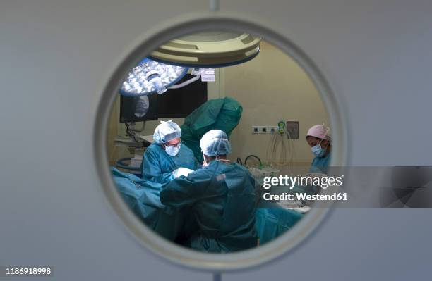 surgeons and nurse during a surgery behind the door - operation theatre stock pictures, royalty-free photos & images