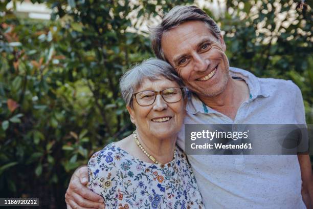 happy mother and adult son in he garden - mutter sohn erwachsen stock-fotos und bilder