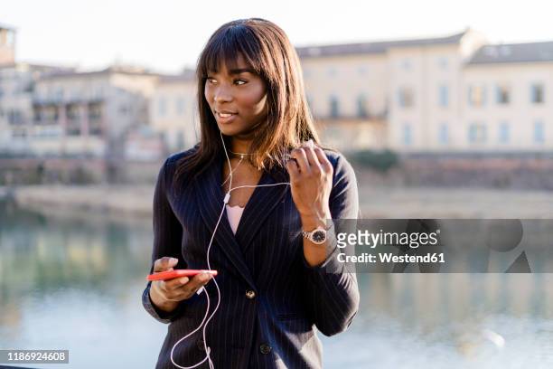 businesswoman using her smartphone outdoors - rivier bos stock-fotos und bilder