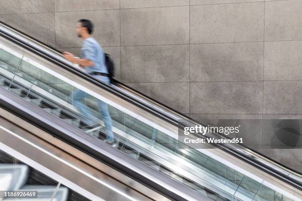 businessman in a hurry walking up escalator in the city, berlin, germany - scala mobile foto e immagini stock