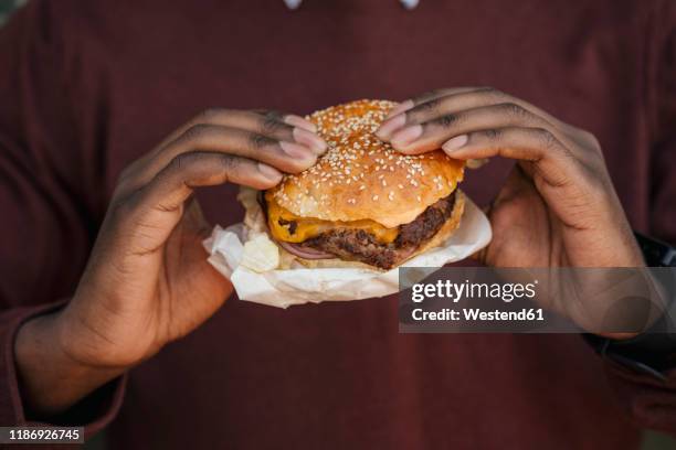 close-up of hands, holding cheeseburger - black man eating stock pictures, royalty-free photos & images