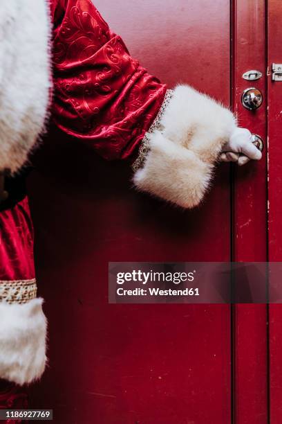 santa claus gloved hands open the door, close up - santa close up stock-fotos und bilder