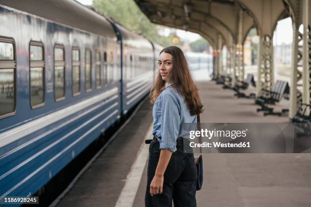 young female traveller on train station - turning back stock pictures, royalty-free photos & images