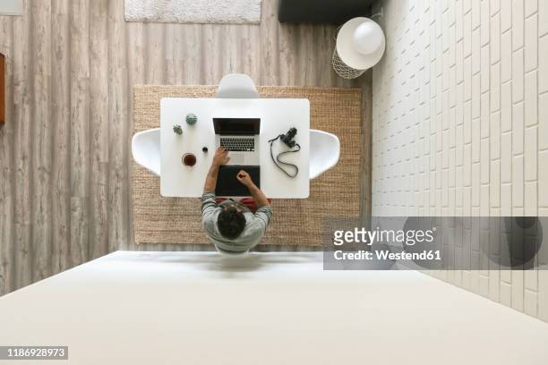 man sitting at table working on graphics tablet and laptop, top view - overhead view stock-fotos und bilder