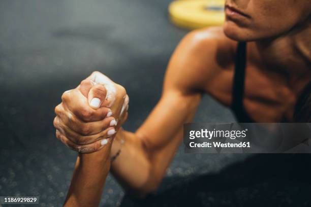 two women in good shape doing arm wrestling challenge in a gym - women wrestling stock-fotos und bilder