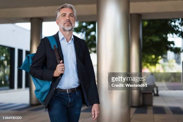 mature businessman with backpack on the go - 55 59 anni foto e immagini stock