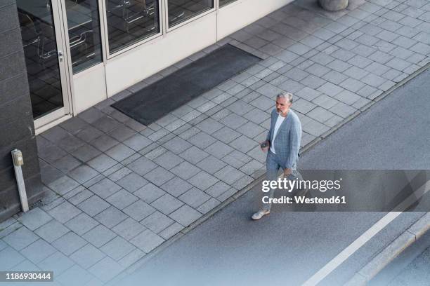 top view of mature businessman walking on a road - grey suit stock-fotos und bilder