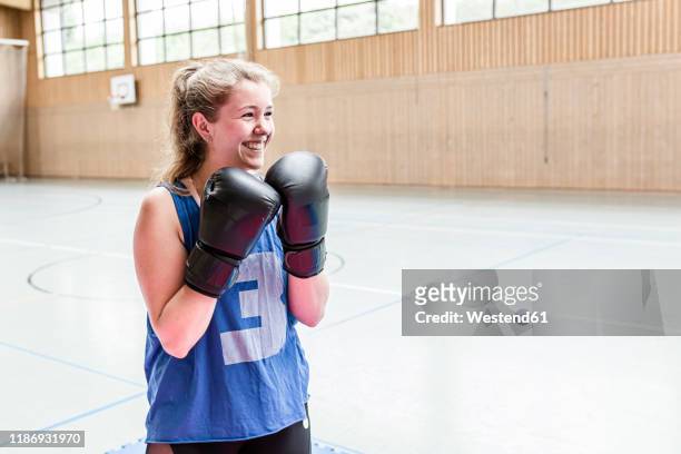happy female boxer in sports hall - desporto de combate imagens e fotografias de stock