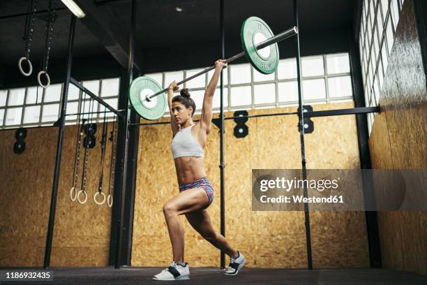 young woman doing overhead squat exercise at gym - kulstång bildbanksfoton och bilder