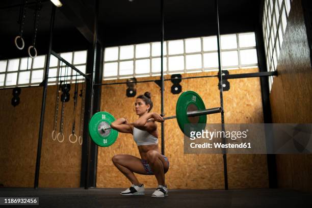young woman doing overhead squat exercise at gym - barbell stock pictures, royalty-free photos & images
