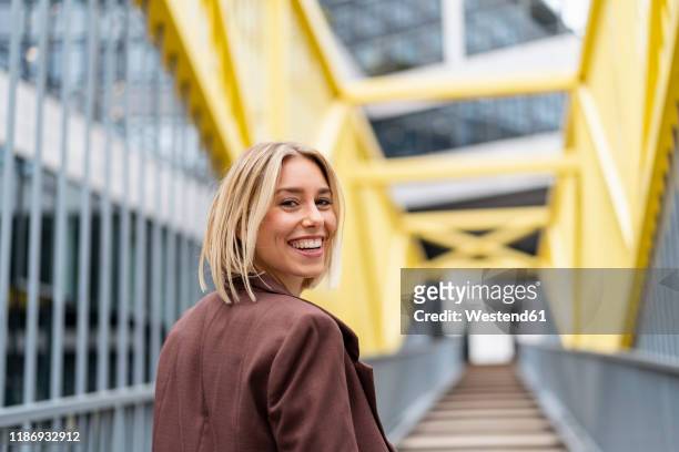 portrait of happy young businesswoman on a bridge in the city - vitality stock-fotos und bilder