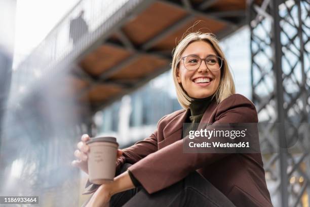 happy young businesswoman with takeaway coffee in the city - coffee happy stockfoto's en -beelden