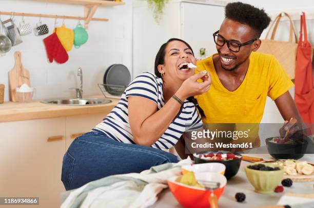 multiethnic couple breakfasting together in the kitchen - ironia imagens e fotografias de stock