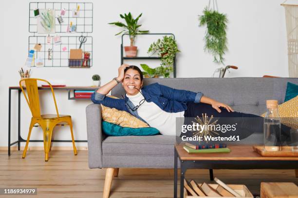young woman resting on a couch at living room - irony stock pictures, royalty-free photos & images