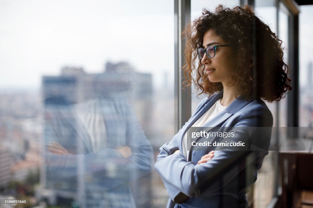 Jonge zakenvrouw kijken door venster