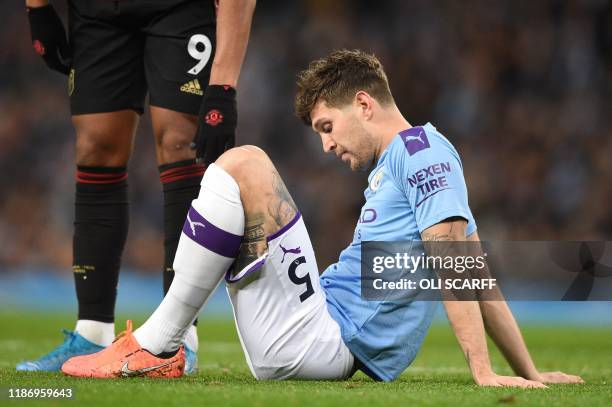 Manchester City's English defender John Stones sits on the pitch injured before being substituted during the English Premier League football match...