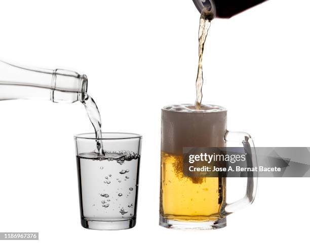 aluminum drink can filling a glass of beer from and a glass of water on a white background. - stein stock pictures, royalty-free photos & images